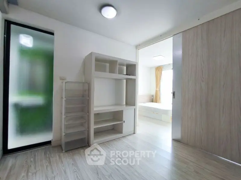 Spacious modern apartment with sleek wooden flooring and ample natural light.