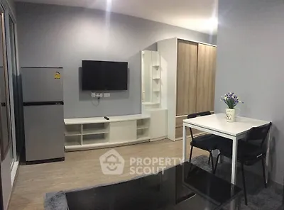 Modern living room with sleek furniture and wall-mounted TV in a stylish apartment.
