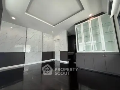 Elegant modern living room with sleek marble walls and dark hardwood floors