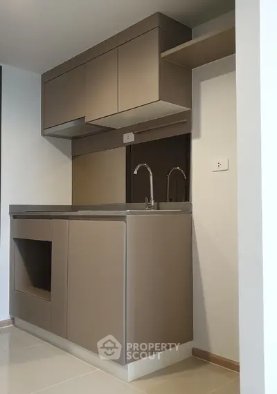 Modern minimalist kitchen with sleek cabinetry and dual faucets