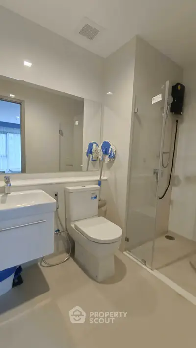 Modern bathroom with glass shower and sleek fixtures in a contemporary apartment.