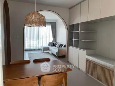 Modern living room with stylish furniture and natural light, featuring a cozy dining area and elegant decor.