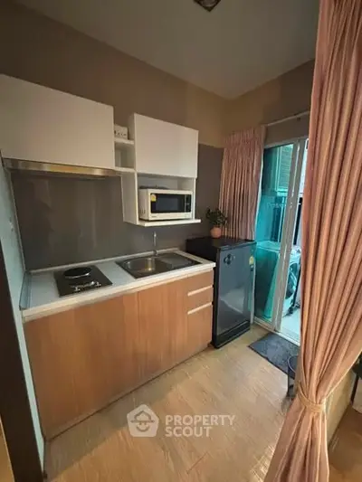 Cozy kitchen with modern appliances and sliding glass door to balcony