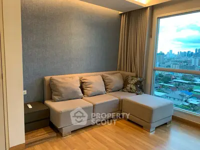 Cozy living room with city view, featuring a comfortable sofa and wooden flooring.