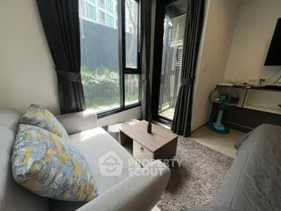 Cozy living room with modern decor and garden view, featuring a comfortable sofa and stylish furnishings.