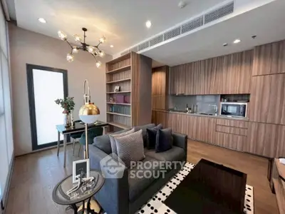 Modern living room with open kitchen, stylish decor, and cozy seating area.