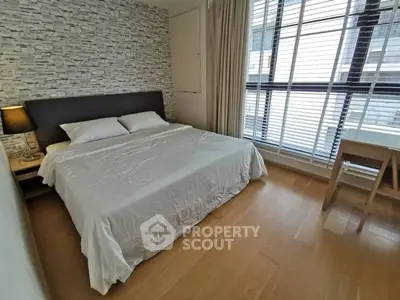 Modern bedroom with large window and stylish decor in a contemporary apartment.