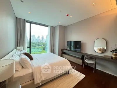 Luxurious bedroom with city view, modern decor, and large window overlooking greenery.
