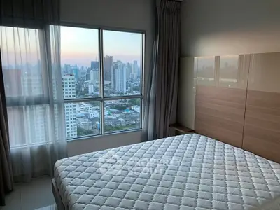 Spacious bedroom with stunning city view from large windows, perfect for urban living.
