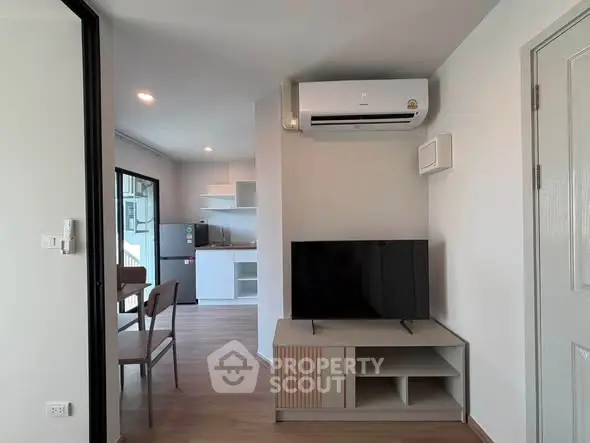 Modern living room with air conditioning and open kitchen layout in a stylish apartment.