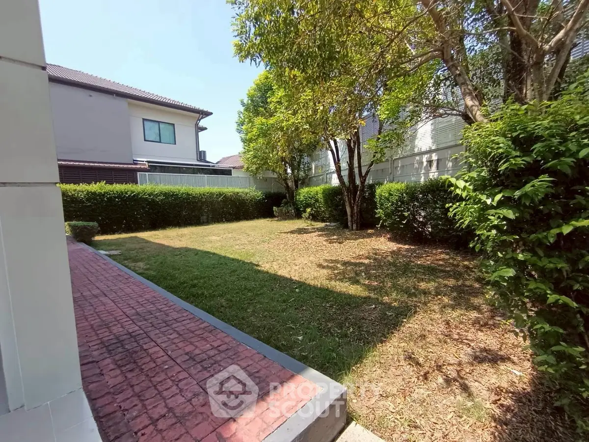 Spacious garden area with lush greenery and trees in a residential property