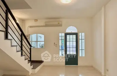Spacious interior with modern staircase and natural light, perfect for stylish living.