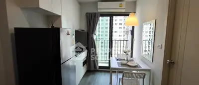 Modern kitchen with dining area and balcony view in urban apartment