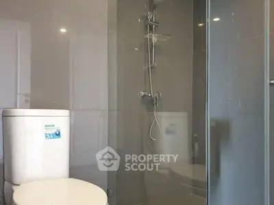 Modern bathroom with glass shower and sleek fixtures in contemporary apartment.