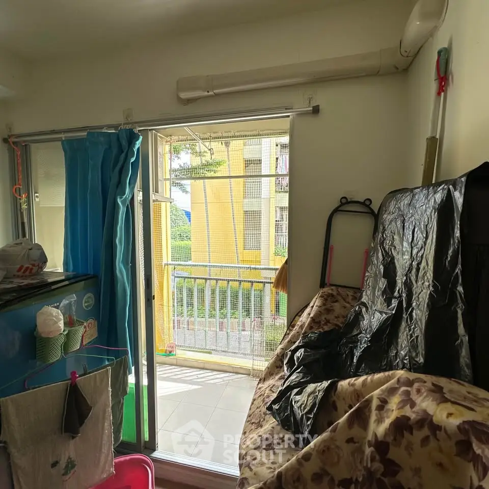 Cozy balcony view with sliding glass door and laundry area in a residential unit.