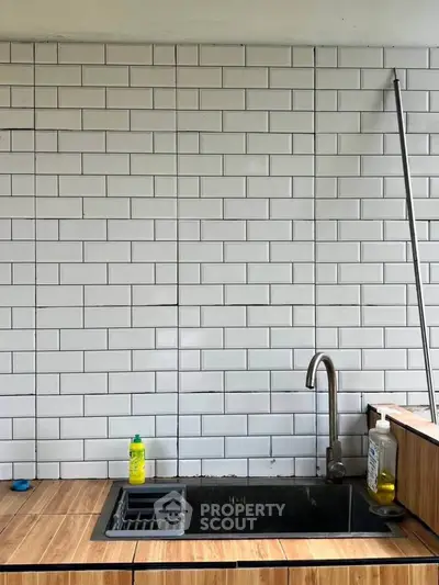 Modern kitchen sink with white subway tiles and wooden countertop
