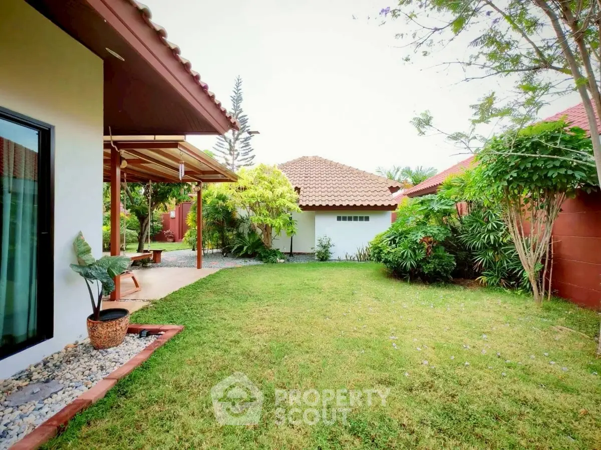 Charming garden view of a suburban home with lush greenery and tiled roofs.