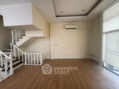 Spacious empty living room with modern staircase and air conditioning