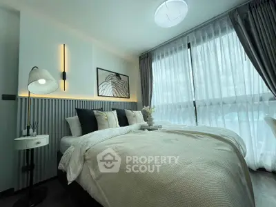 Modern bedroom with large windows and stylish decor in a high-rise apartment.