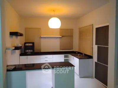 Charming kitchen space with modern appliances and ample counter space, featuring a sleek design and warm lighting.