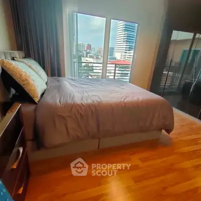 Spacious bedroom with city view and elegant wooden flooring