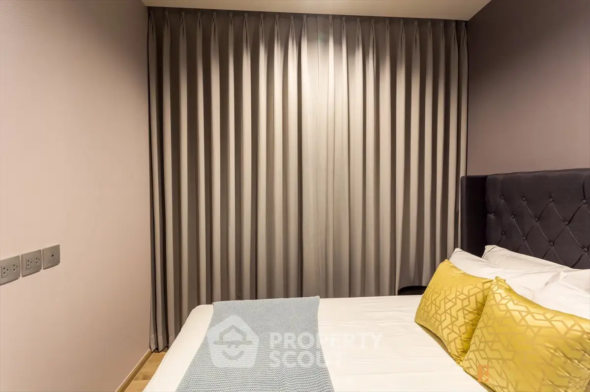 Cozy bedroom with elegant curtains and plush pillows for a serene retreat.