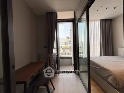 Modern bedroom with balcony access and study area, featuring sleek design and natural light.