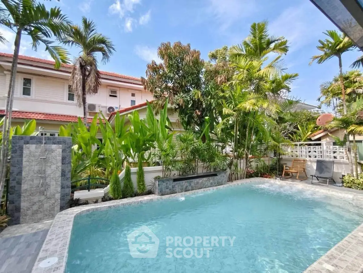 Stunning tropical backyard with a sparkling pool and lush greenery, perfect for relaxation and entertainment.