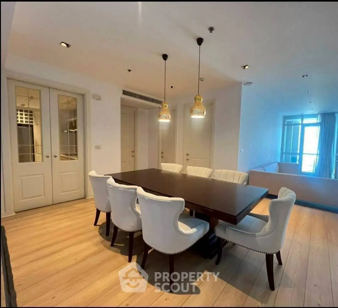 Spacious dining area with elegant lighting and modern furniture in a luxurious apartment.
