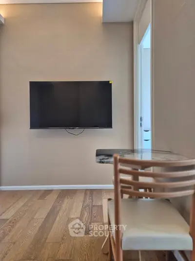 Modern living room with wall-mounted TV and stylish dining area