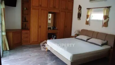 Spacious bedroom with wooden wardrobe and modern decor