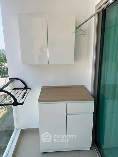 Modern balcony with storage cabinets and laundry rack, perfect for urban living.