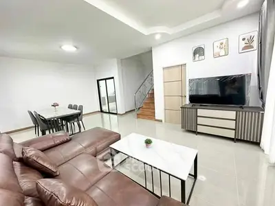 Spacious living room with modern decor and large TV, perfect for family gatherings.