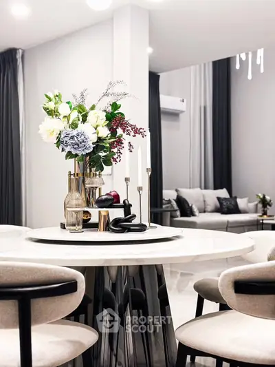 Elegant modern dining area with stylish decor and cozy living room view.