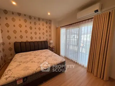 Spacious bedroom with elegant decor and large window for natural light