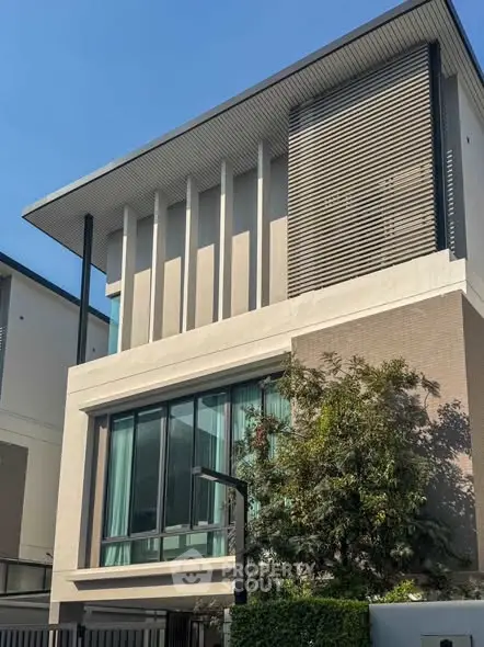 Modern architectural building exterior with large windows and sleek design.