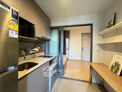 Modern compact kitchen with sleek cabinetry and open layout in cozy apartment