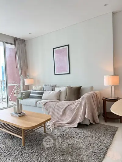 Modern living room with cozy sofa, stylish decor, and balcony view in a high-rise apartment.