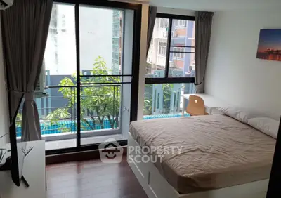 Modern bedroom with large windows and balcony view in urban apartment