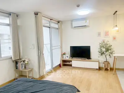 Modern bedroom with balcony access, featuring stylish decor and natural light.