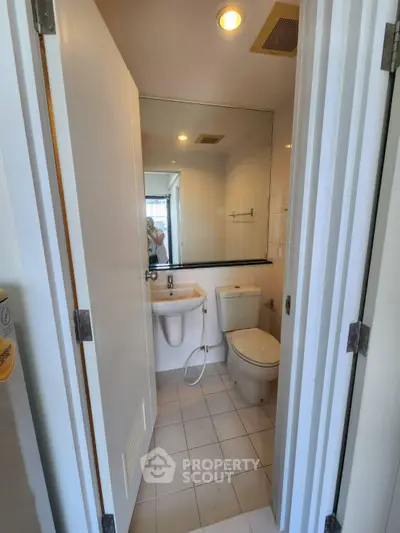 Compact bathroom with modern fixtures and large mirror