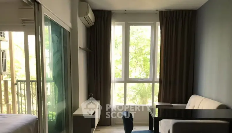 Modern living room with large windows and natural light in a stylish apartment.