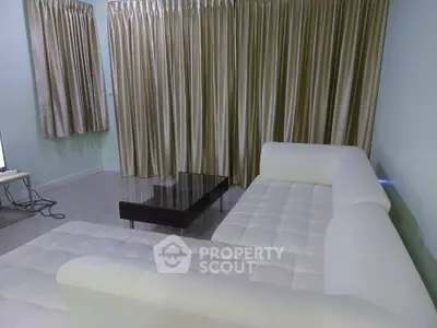 Modern living room with white sectional sofa and elegant curtains