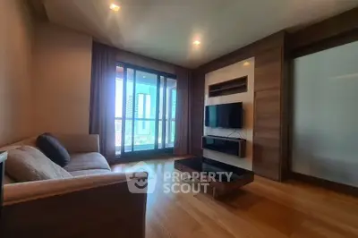 Modern living room with large windows and stylish furniture in a high-rise apartment.