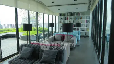 Luxurious living room with panoramic windows and garden view, featuring modern sofas and stylish decor.