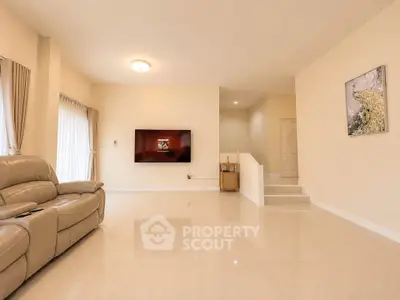 Spacious living room with modern decor and wall-mounted TV, perfect for family gatherings.
