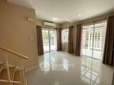 Spacious living room with large windows and balcony access in modern home