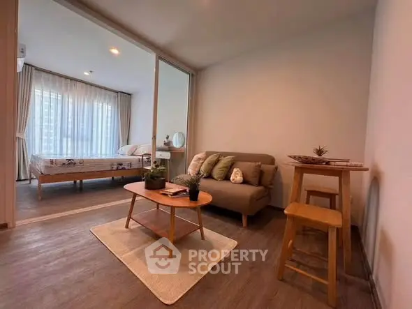 Modern living room with cozy sofa and stylish decor adjacent to a bright bedroom.