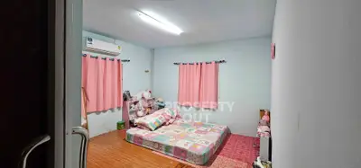 Cozy bedroom with pastel decor and air conditioning, perfect for a restful retreat.