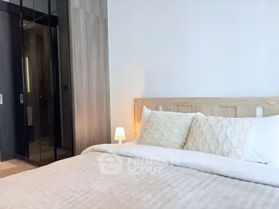 Elegant bedroom with cozy bedding and modern wooden accents, perfect for relaxation.